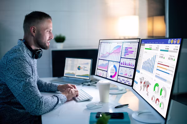A freelancer working on a laptop with AI tools and analytics dashboards open