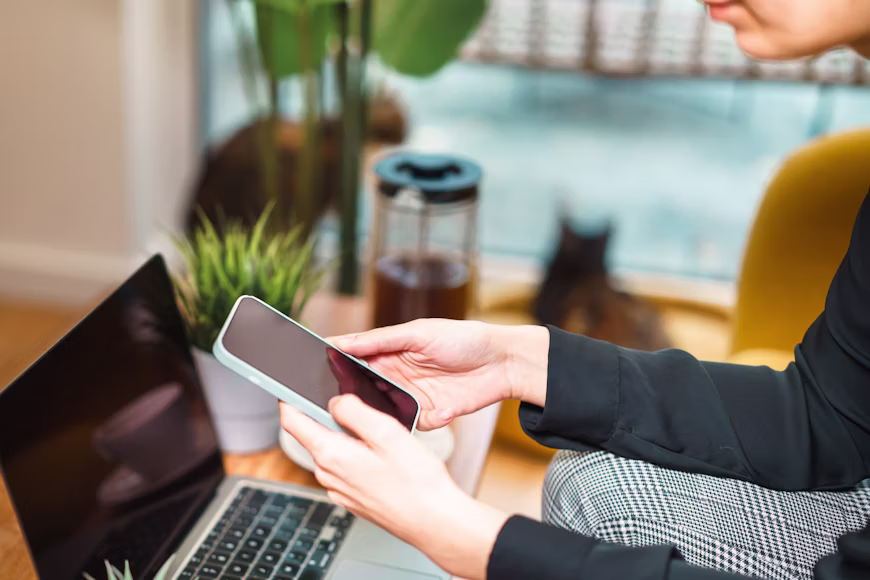 A person using Google Gemini on a laptop and smartphone with Google Workspace apps open in the background