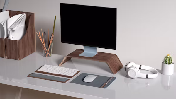 A clean home office setup featuring a monitor, ergonomic chair, desk lamp, and cable management under $300 total cost