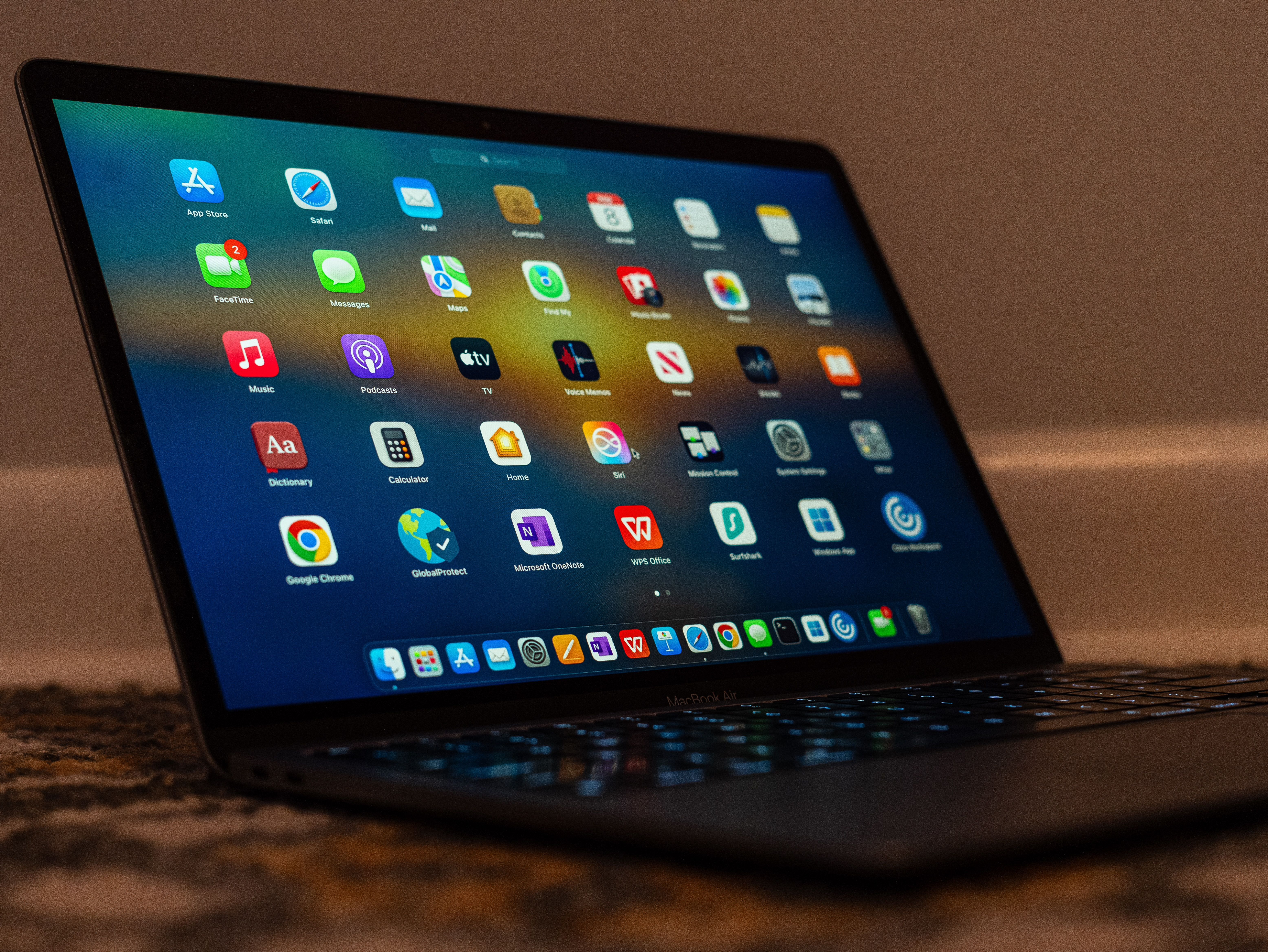 A desk with a laptop and phone showing free productivity app icons for tasks, notes, and focus